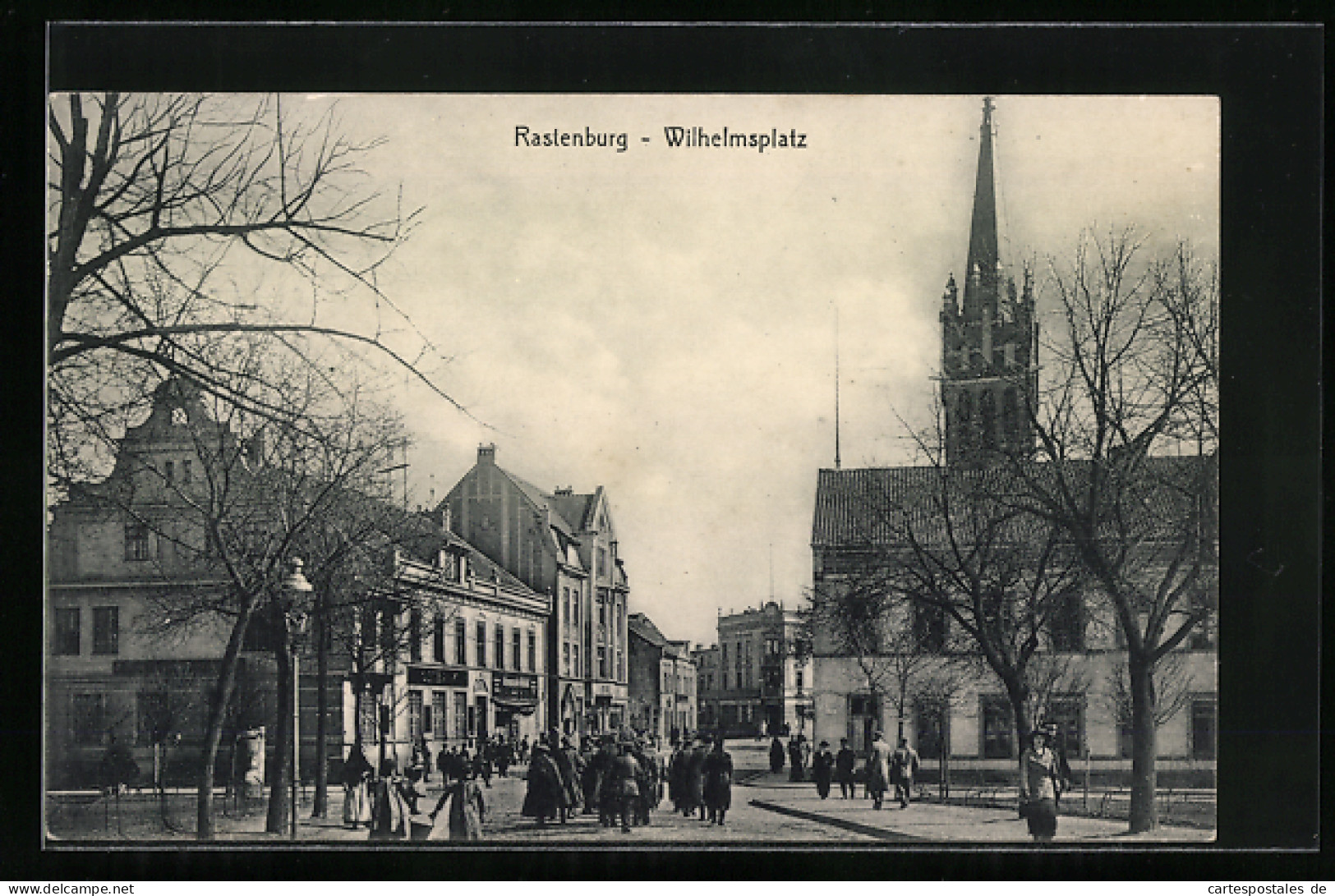 AK Rastenburg, Geschäfte am Wilhelmsplatz, Kirche