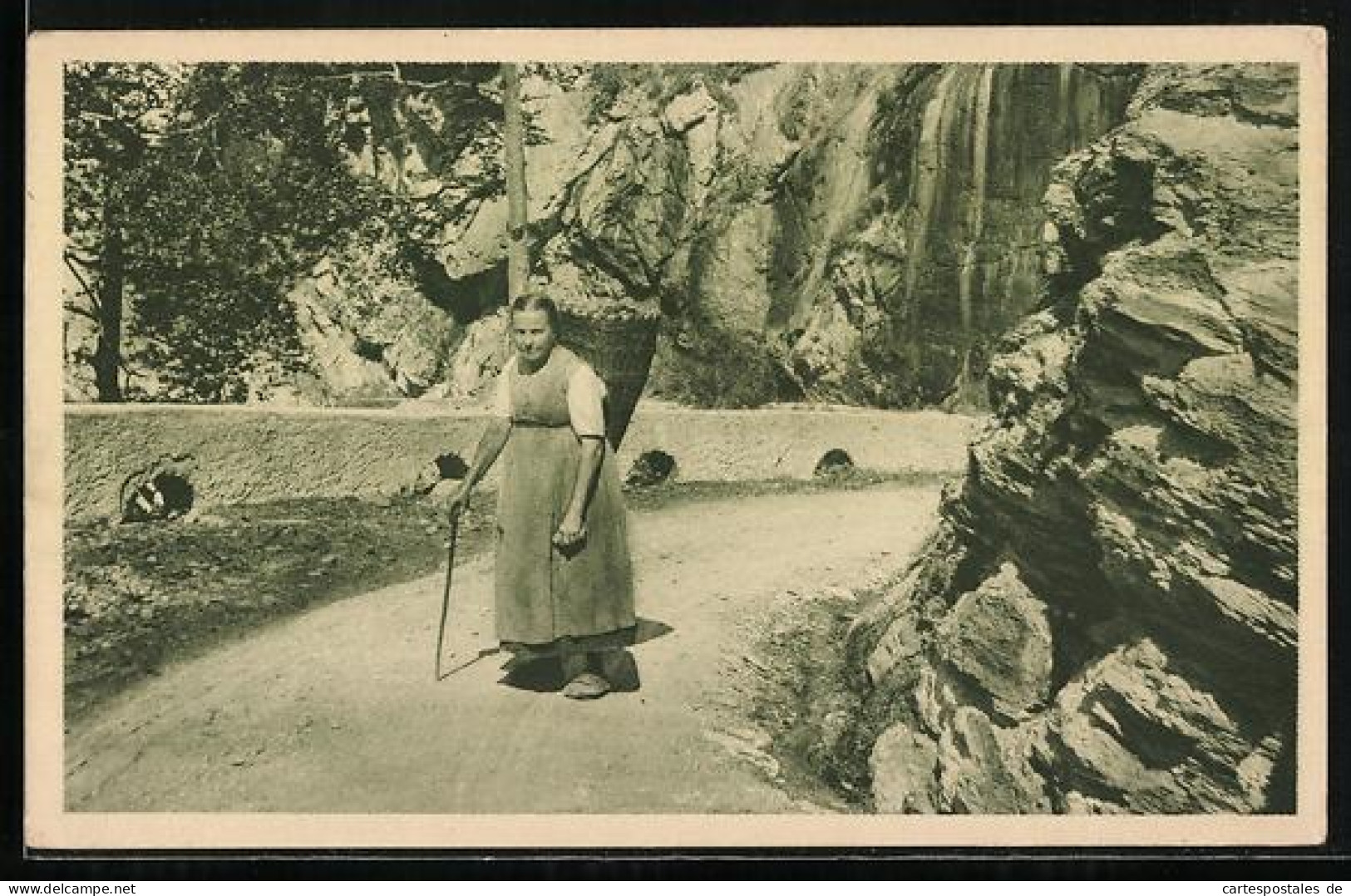 AK Riemenstalden, Frau mit Stock und Korb auf dem Rücken