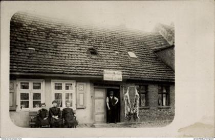 Photo CPA Putlitz in der Prignitz, Fleischerei Genske, drei Frauen auf der Bank vor dem Haus