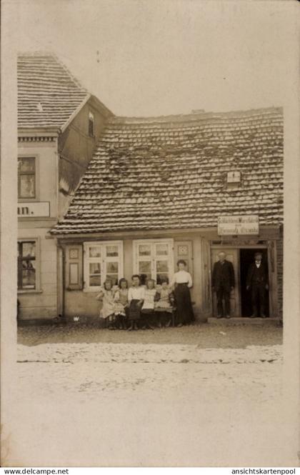 Photo CPA Putlitz in der Prignitz, Fleischerei Genske, Männer an der Tür, Frau und Kinder vor dem Haus