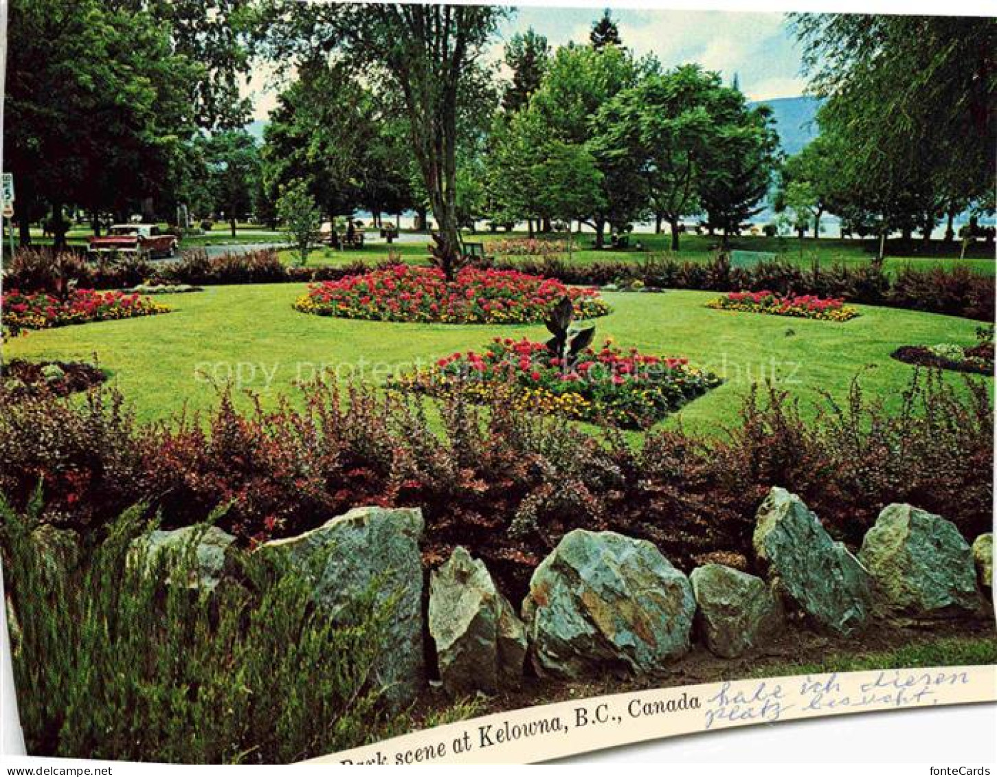 Kelowna British Columbia Canada Park Blumenbeete Rasen Baeume See Felsen Okanaga