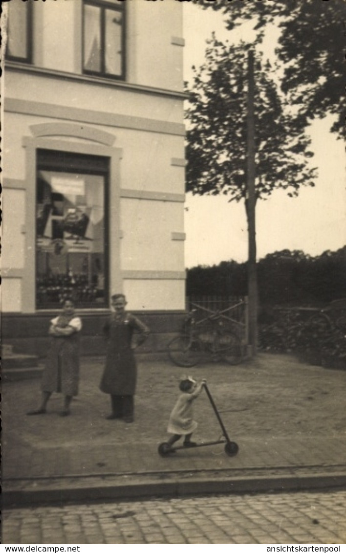 Photo CPA Kirchweyhe Weyhe Niedersachsen, Geschäftshaus, Schaufenster, Anwohner, Kind mit Roller