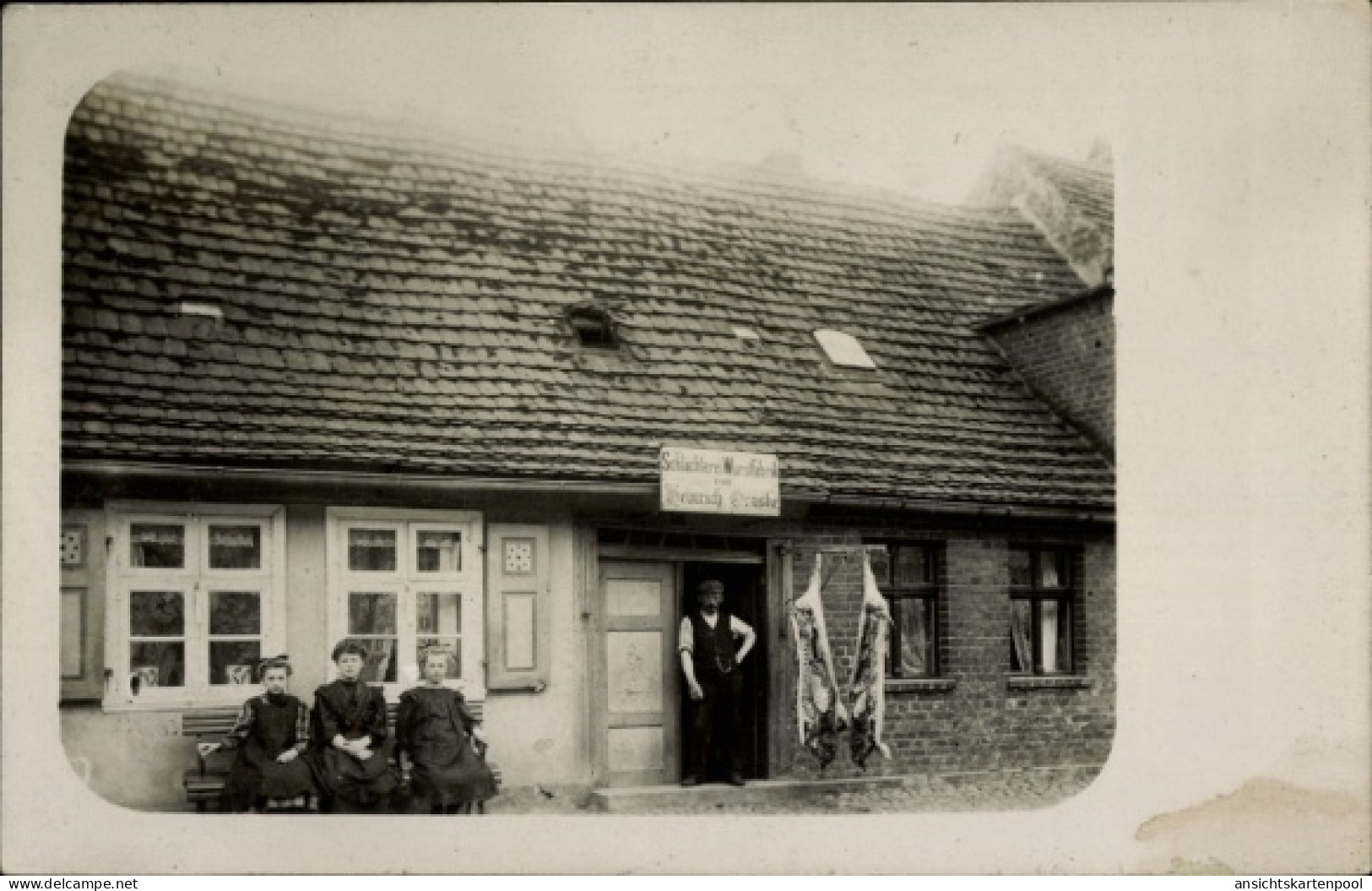 Photo CPA Putlitz in der Prignitz, Fleischerei Genske, drei Frauen auf der Bank vor dem Haus