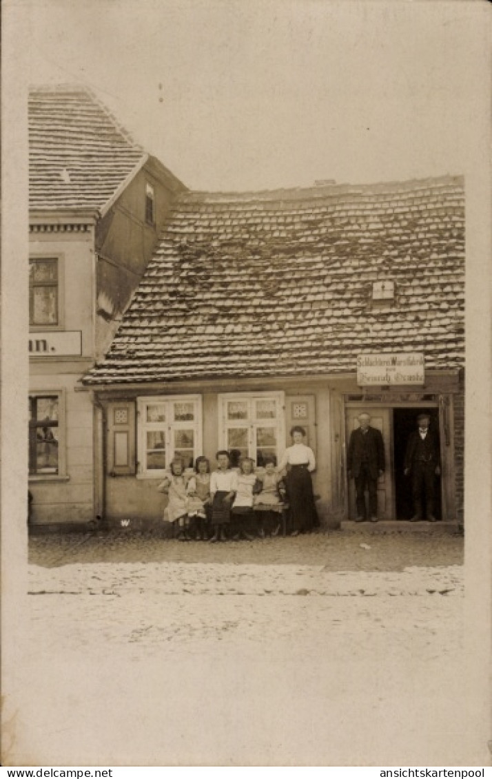 Photo CPA Putlitz in der Prignitz, Fleischerei Genske, Männer an der Tür, Frau und Kinder vor dem Haus