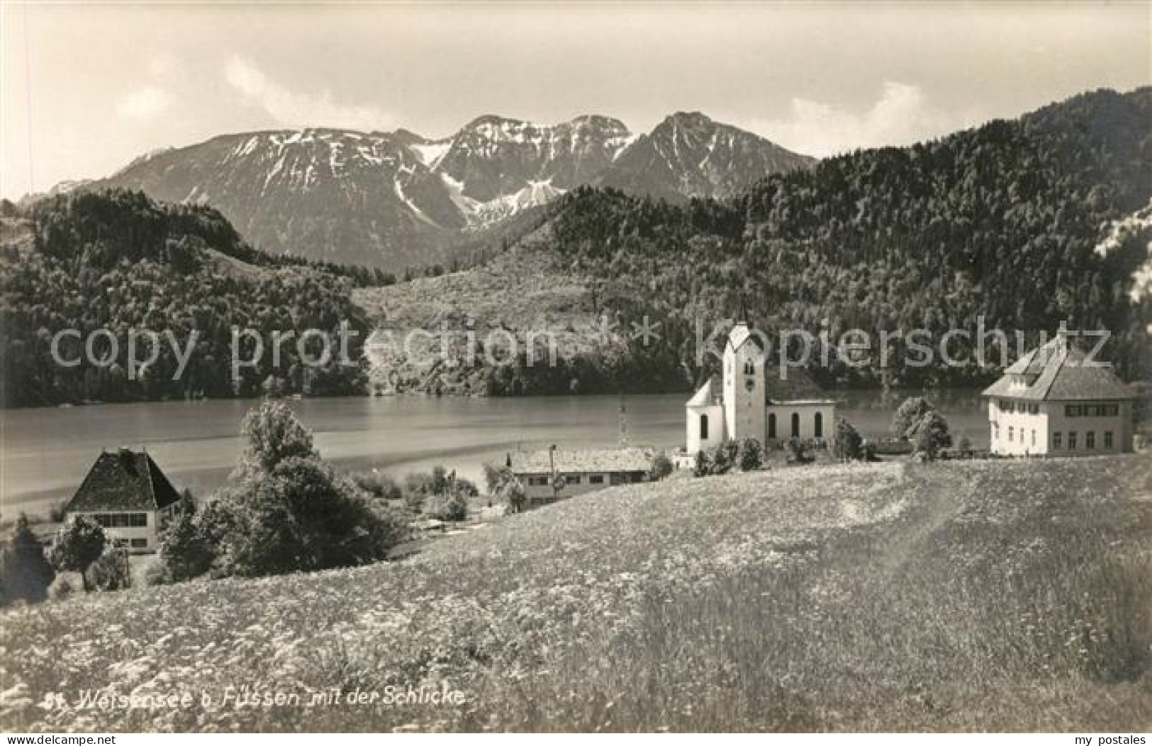 Weissensee Fuessen Teilansicht mit Kirche Weissensee und der Schlicke Allgaeuer